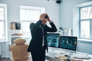 Frustrated young man in formalwear going through emotional stress while working in the office