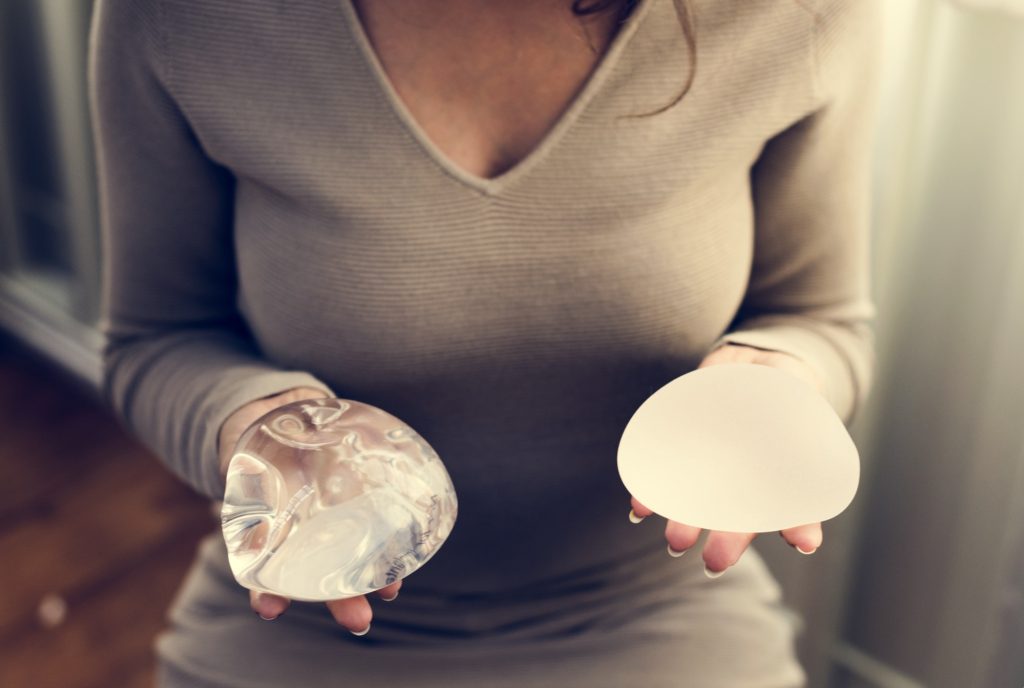 Woman holding silicon bags for breast implant